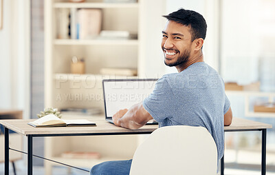 Buy stock photo Shot of a young businessman using a laptop in an office at work
