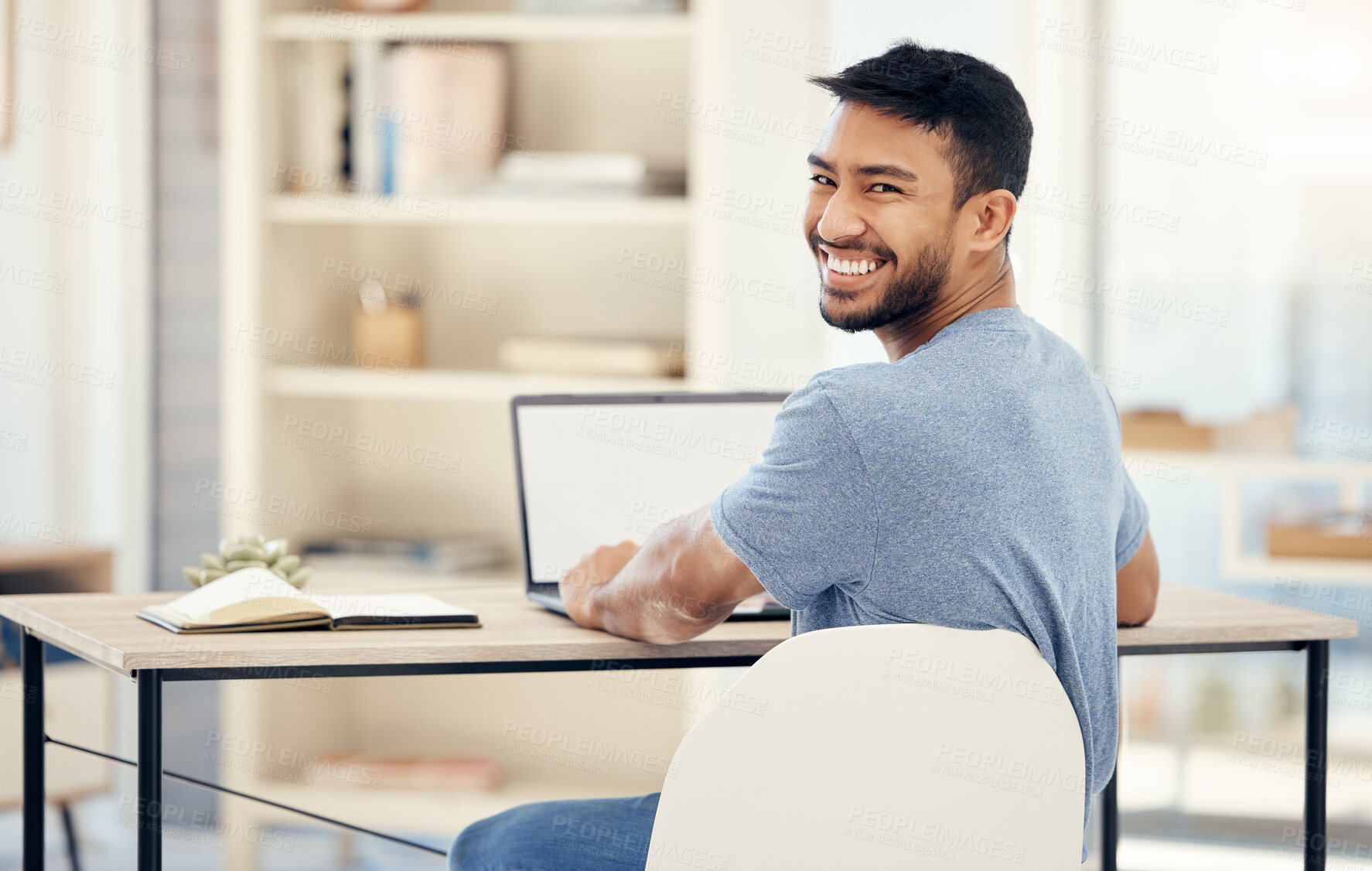 Buy stock photo Shot of a young businessman using a laptop in an office at work