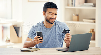 Buy stock photo Shot of a young businessman using a credit card and phone at work