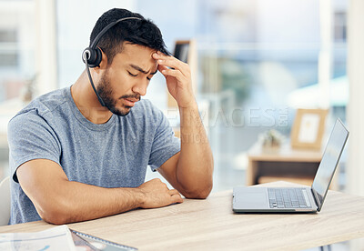 Buy stock photo Shot of a young male call center agent suffering from a headache while at work