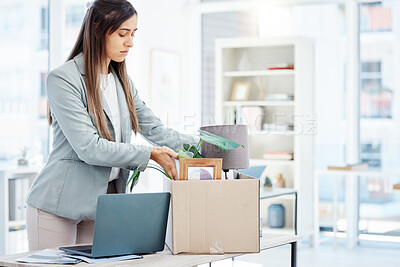 Buy stock photo Shot of a young businesswoman packing a box in an office