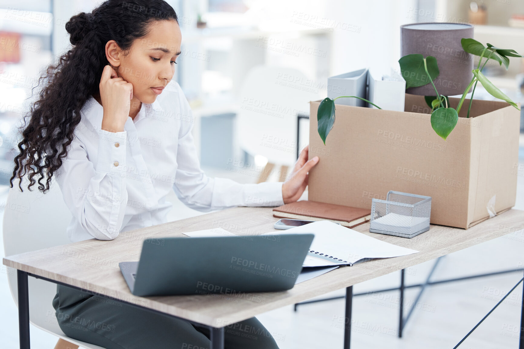 Buy stock photo Shot of a young businesswoman packing a box in an office