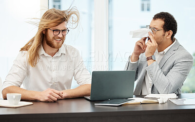 Buy stock photo Shot of a young businessman sneezing in his colleague's face in an office