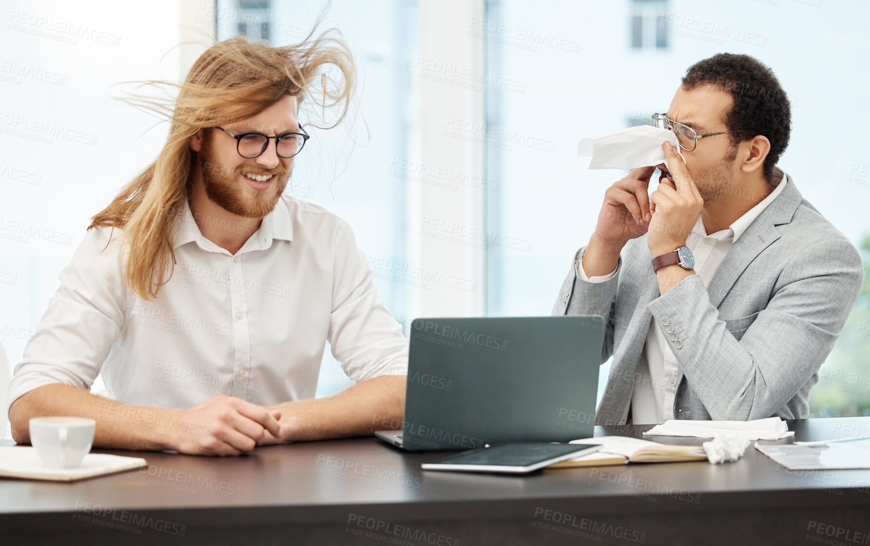 Buy stock photo Shot of a young businessman sneezing in his colleague's face in an office
