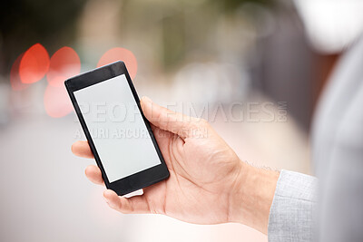 Buy stock photo Shot of an unrecognizable businessperson holding a phone in the city