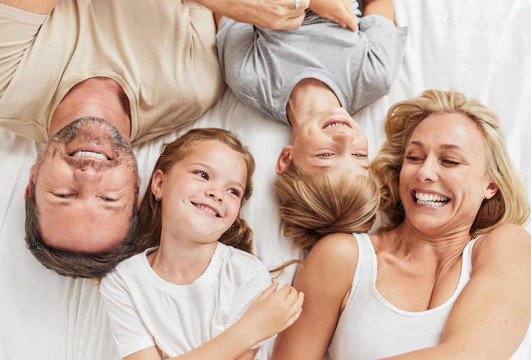 Buy stock photo Family, happy and relax on bed in home with playing, resting and bonding with weekend fun. Parents, kids and smile with top view for support, laughing and relationship with playful, affection or love