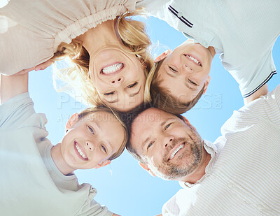 Buy stock photo Low angle shot of a family of four standing in a huddle