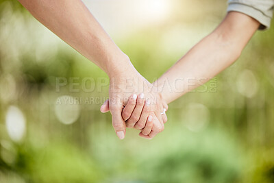 Buy stock photo Cropped shot of a woman holding her son's hand while walking outside