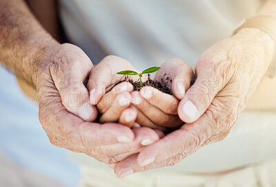 Buy stock photo Shot of a senior man cupping a boy's hands while holding a plant growing out of soil