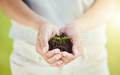 Buy stock photo Cropped shot of a man holding a plant growing out of soil