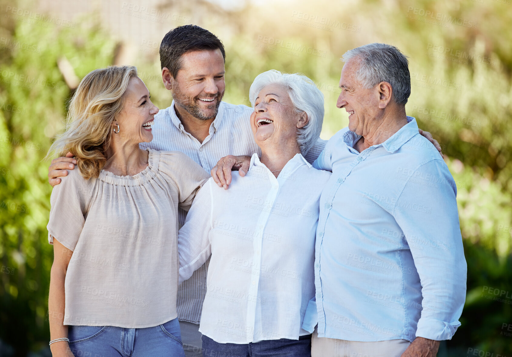 Buy stock photo Happy, love and big family hug laughing in park for holiday, travel or weekend trip. Nature, smile and couple embrace elderly parents for vacation, retirement and bonding together with funny joke