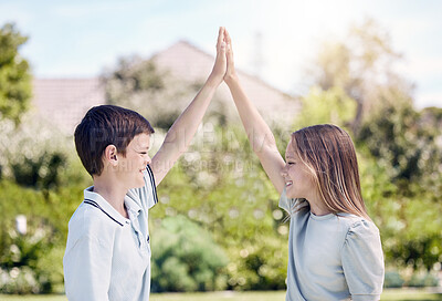 Buy stock photo Shot of a young boy and girl giving each other a high-five while standing outside