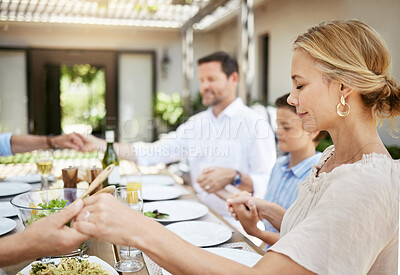 Buy stock photo Shot of a family saying grace while sitting together at the dining table