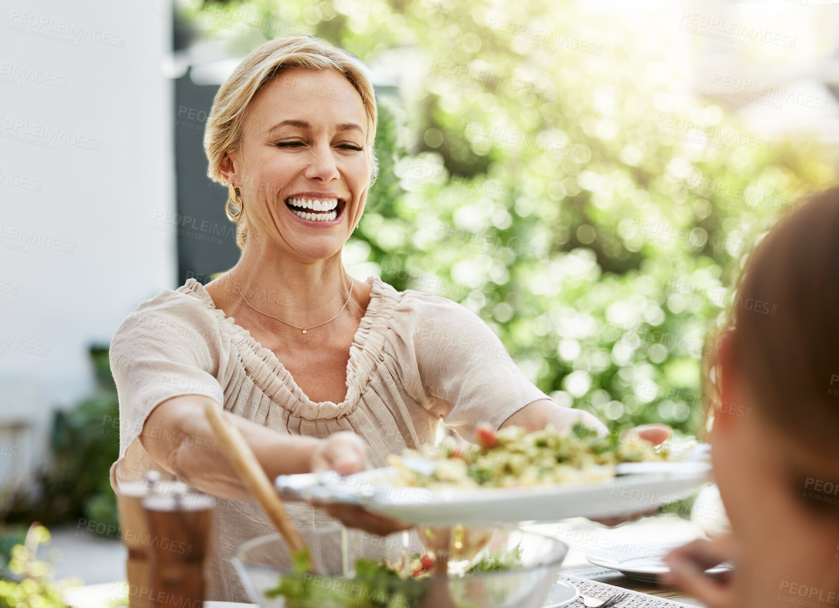 Buy stock photo Family, woman and salad in backyard for lunch, sharing and healthy meal in summer. Female person, food and smile on estate for birthday party, Thanksgiving and happiness at outdoor table at house