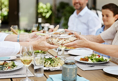 Buy stock photo Cropped shot of people passing food around the dining table