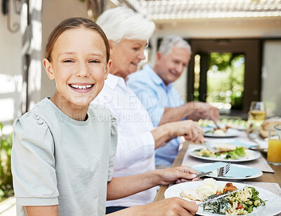 Buy stock photo Shot of an adorable little girl enjoying a meal with her family at home