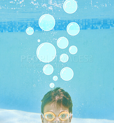 Buy stock photo Shot of a little boy swimming underwater with bubbles above his head