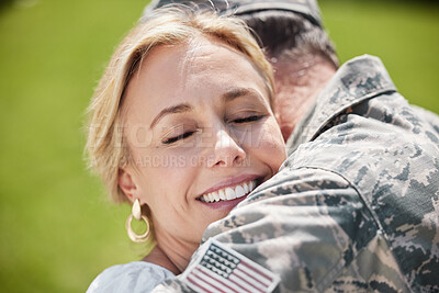 Buy stock photo Shot of a man returning from the army hugging his wife outside