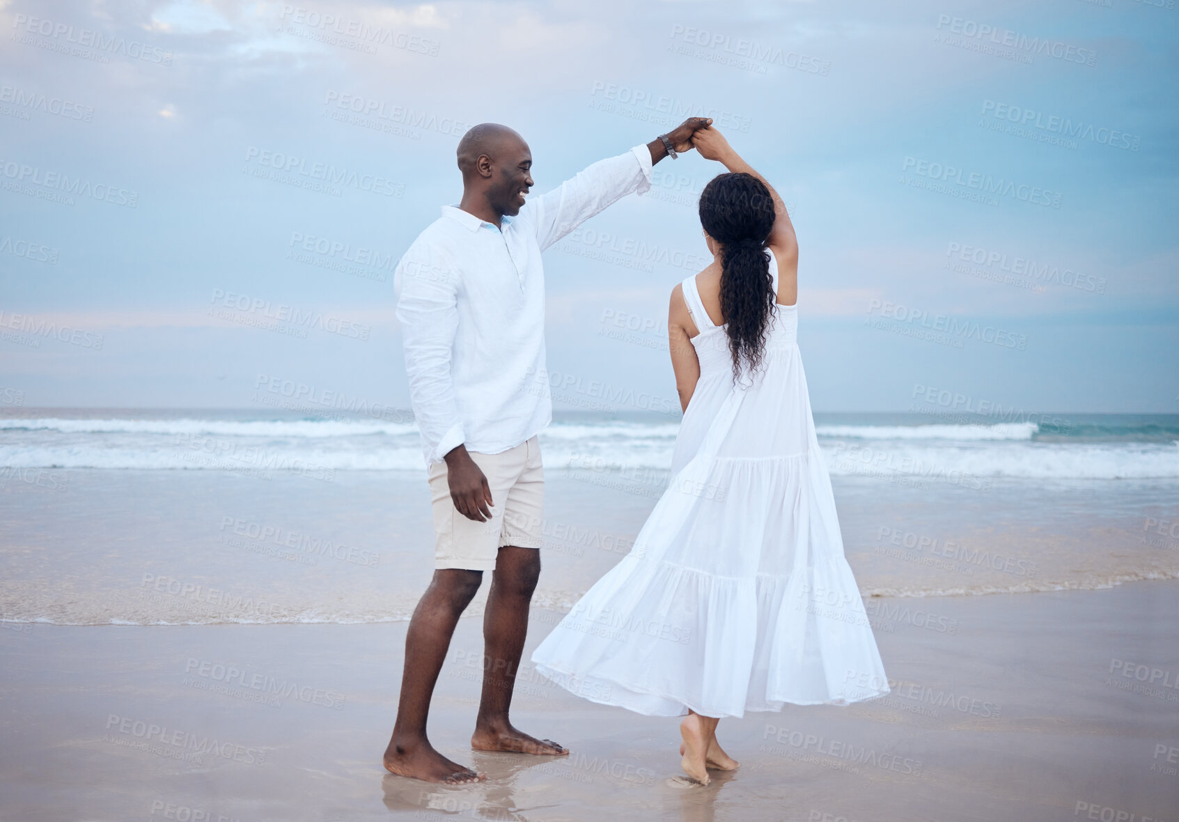 Buy stock photo Dancing, honeymoon and black couple holding hands at beach for support, trust or travel together on date. Smile, sea and people romantic anniversary for holiday or marriage commitment in Mauritius