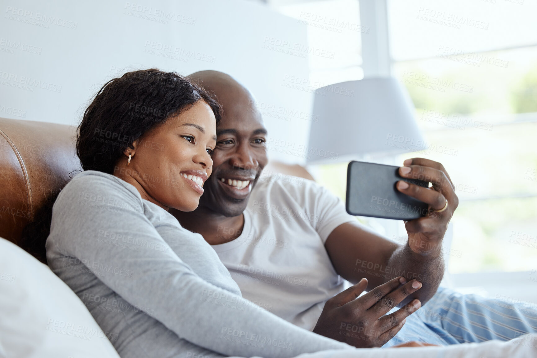 Buy stock photo Happy black couple, phone and video call in bed for communication, talk or relax. Man, woman and virtual chat in bedroom for news, story or live streaming for recording memory online for love in home