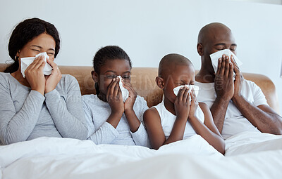 Buy stock photo Shot of a family blowing their noses while sick at home