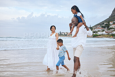 Buy stock photo Shot of a beautiful family bonding while spending a day at the beach together
