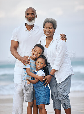 Buy stock photo Shot of a mature couple bonding with their grandkids at the beach