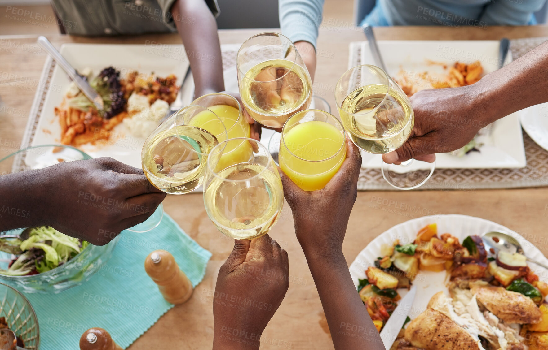 Buy stock photo Shot of a unrecognizable family toasting during lunch at home