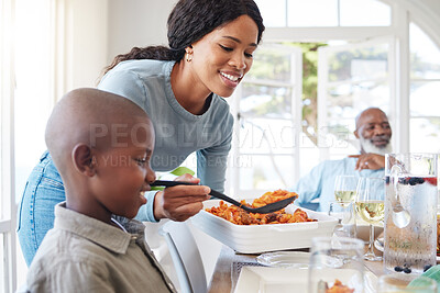 Buy stock photo Shot of a mother dishing food for her son at home