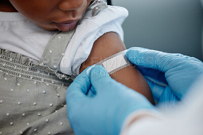 Buy stock photo Closeup shot of an unrecognisable doctor applying a plaster to a little girl's arm after an injection