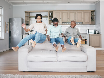 Buy stock photo Shot of a family jumping on to the sofa at home
