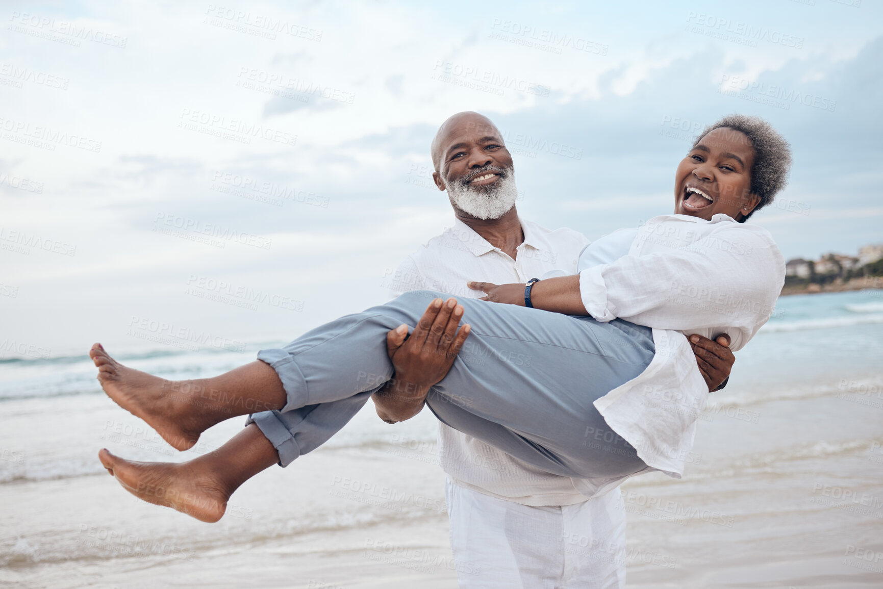 Buy stock photo Happy, portrait and senior black couple on beach for travel, vacation or getaway with bonding. Love, excited and elderly man carrying wife by ocean or sea for retirement holiday together in Morocco.