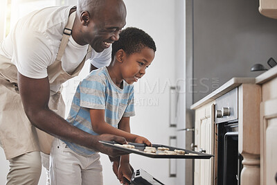 Buy stock photo Shot of a father and son standing by the oven in the kitchen