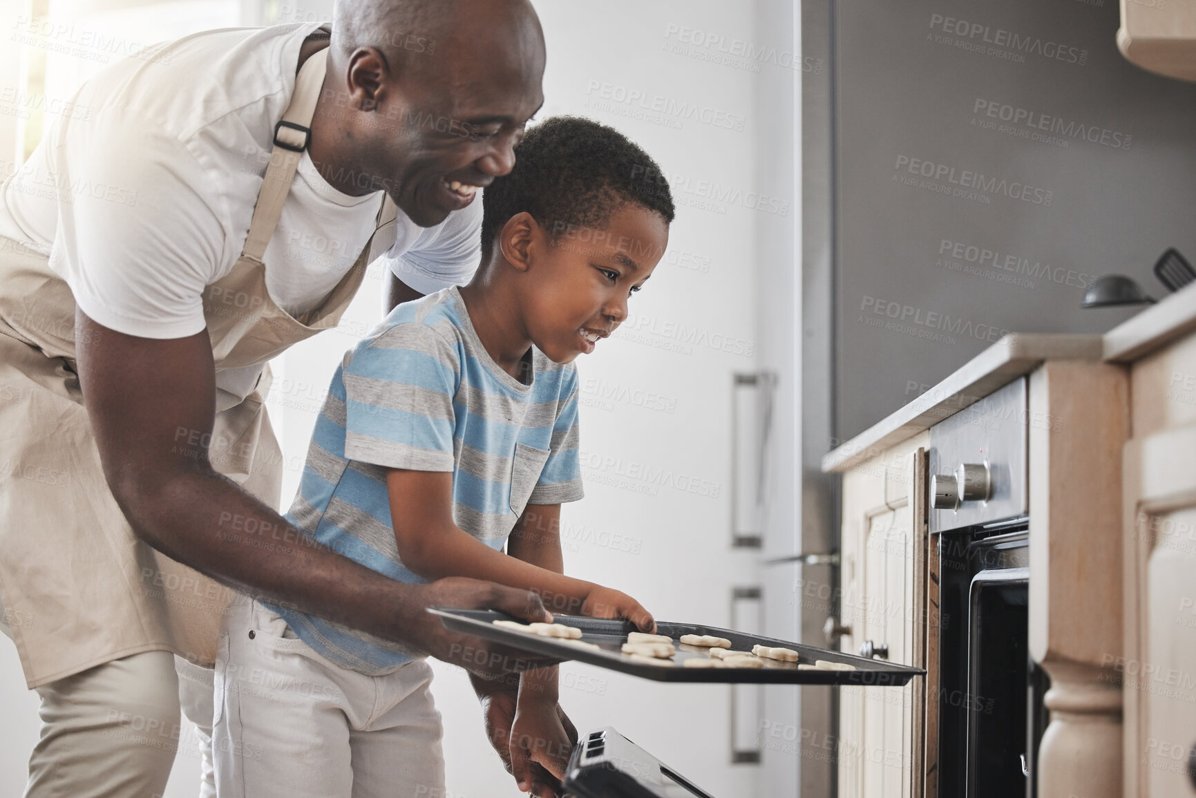 Buy stock photo Baking, cooking in oven and father with son in kitchen of home together for child development.  Help, love and smile of black family in apartment with single parent man teaching boy child how to bake