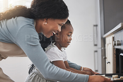 Buy stock photo Shot of a little girl and her mother standing in front of the oven
