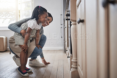 Buy stock photo Shot of a little girl and her mother sitting in front of the oven