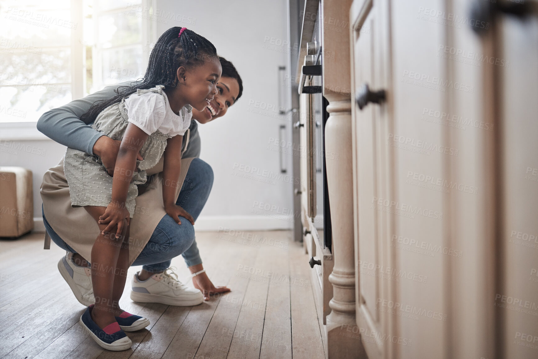 Buy stock photo Baking in oven, help and mom with daughter in home kitchen together for child development. Cooking, love and smile of black family in apartment with single parent woman teaching girl kid how to bake