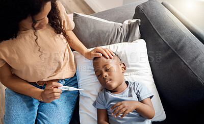 Buy stock photo High angle shot of a young mother checking her sick son's temperature at home
