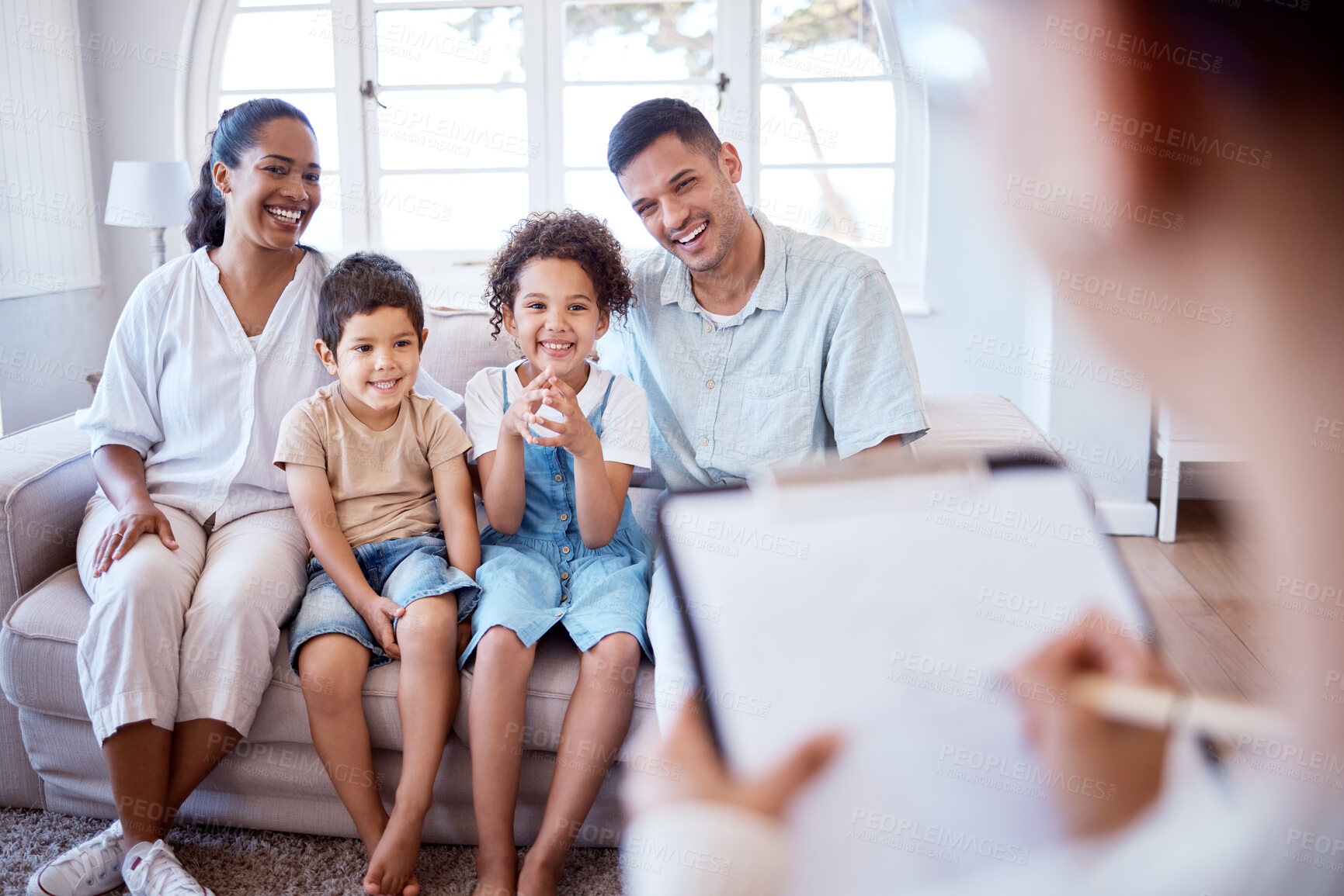 Buy stock photo Parents, children and psychology with family therapy, smile and together on sofa, support and discussion. Young kids, mom and dad on couch with psychologist, listening and talking for mental health