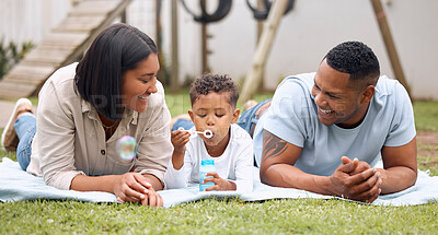 Buy stock photo Shot of a family having fun  while their son blows bubbles outside