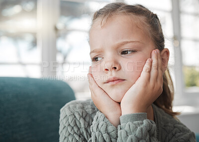 Buy stock photo Shot of a young girl looking bored at home