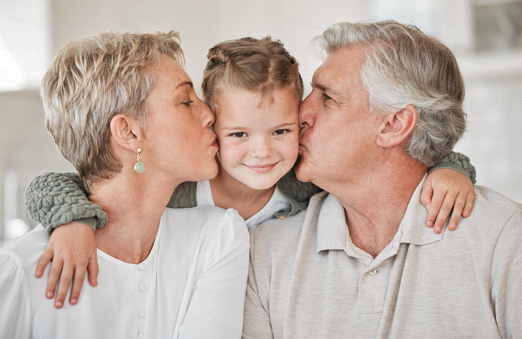 Buy stock photo Happy, kiss and portrait of child with grandparents in home for bonding, connection and family time. Smile, love and girl kid hugging senior man and woman with care on sofa in living room at house.