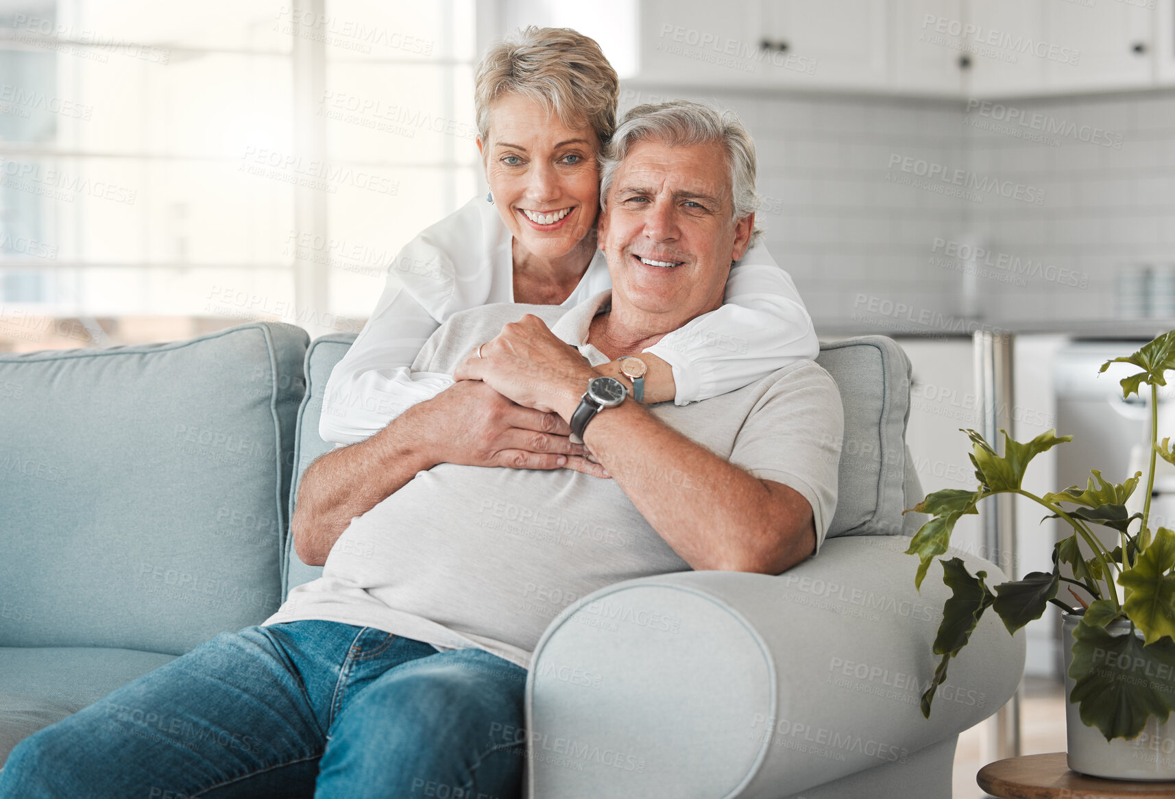 Buy stock photo Hug, senior couple and portrait on sofa with love, connection and bonding together in home. House, woman and man on couch in retirement, commitment and security and embrace support in marriage