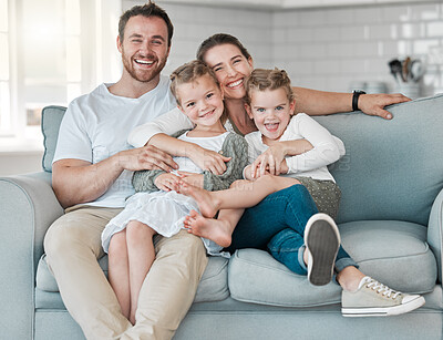 Buy stock photo Shot of a young family bonding together on a sofa at home