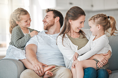 Buy stock photo Shot of a young family bonding together on a sofa at home