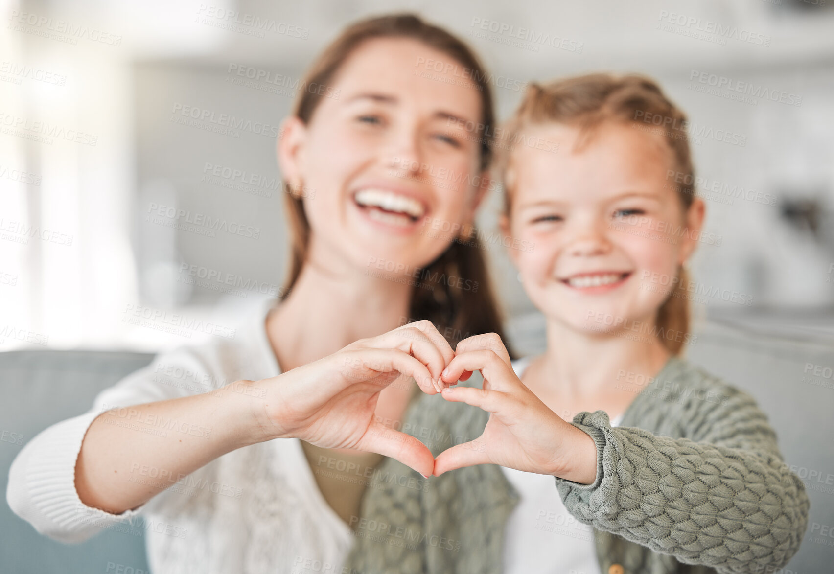 Buy stock photo Happy mother, portrait and daughter with heart hands for love, care or support together at home. Mom, young child or little girl with smile, emoji or sign for like, bonding or shape on sofa at house