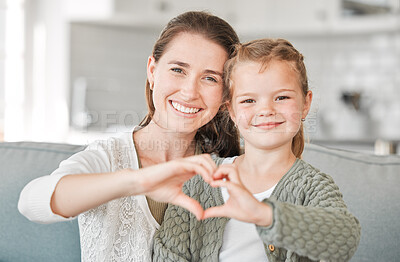 Buy stock photo Happy mom, portrait and daughter with heart hands for love, care or support together at home. Mother, young child or little girl with smile, emoji or sign for like, bonding or shape on sofa at house