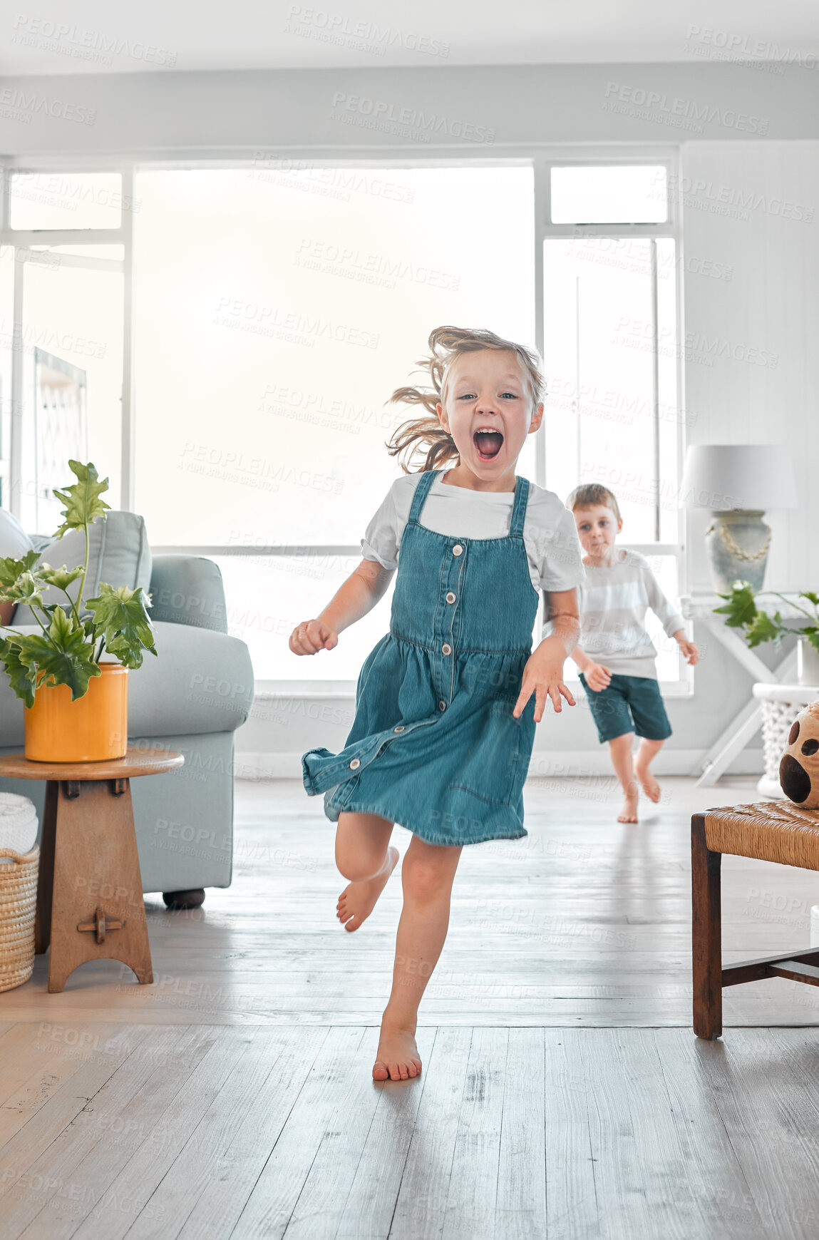 Buy stock photo Shot of a brother and sister running inside the house