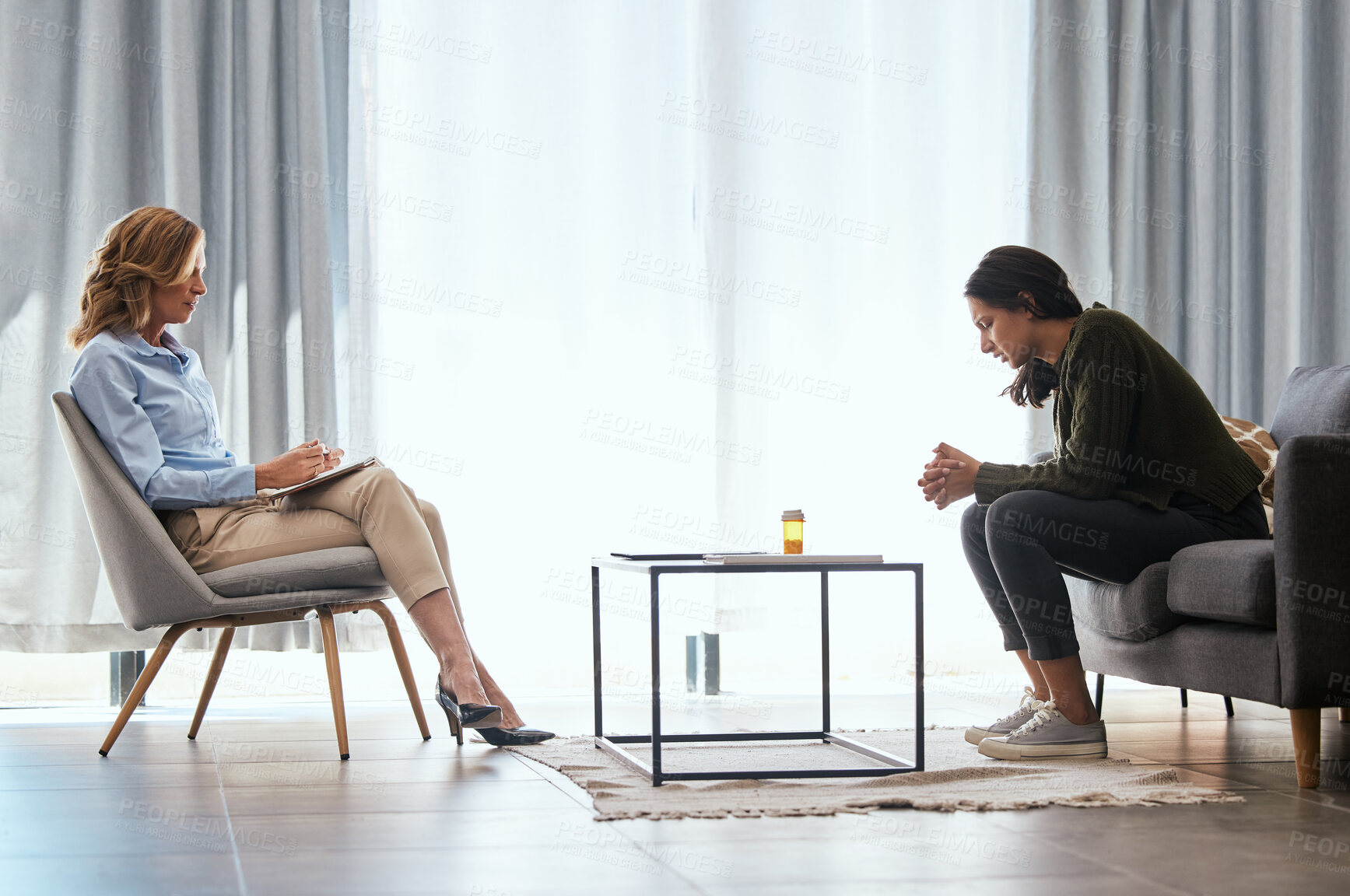 Buy stock photo Shot of a young woman having a therapeutic session with a psychologist