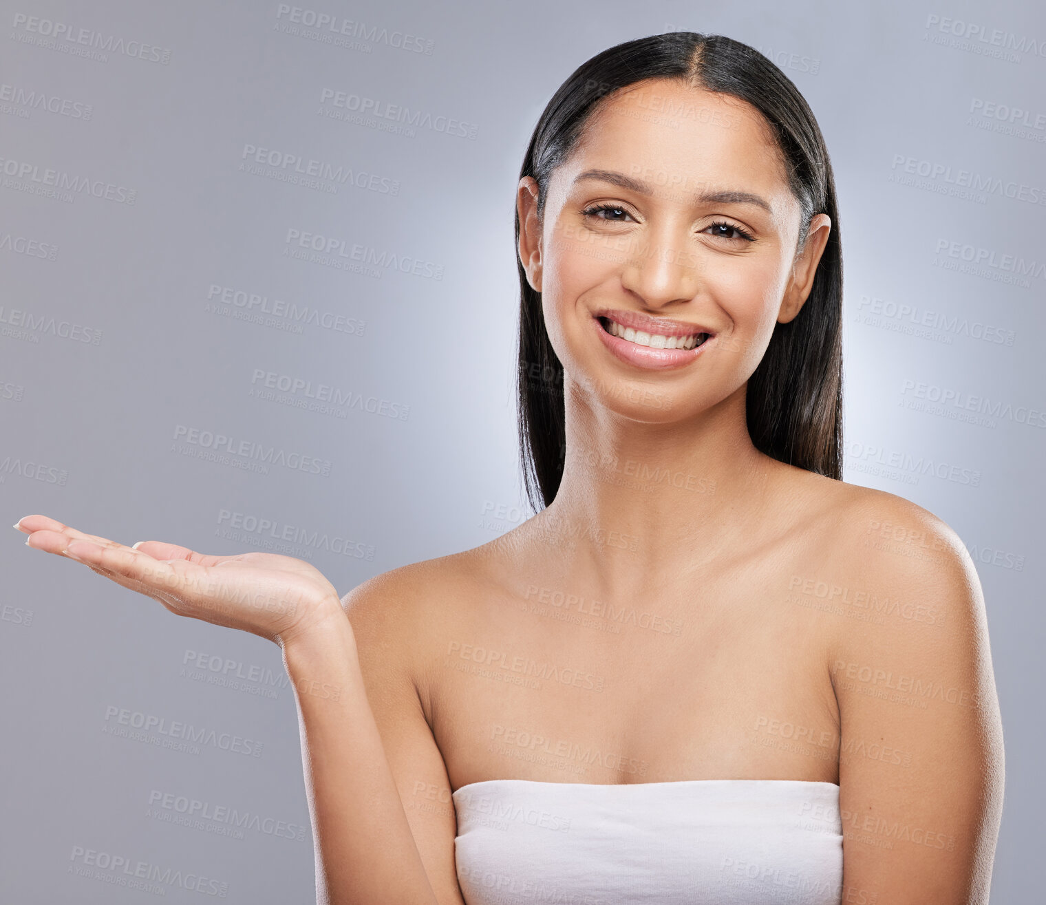 Buy stock photo Studio shot of a beautiful young woman holding out her hand against a grey background